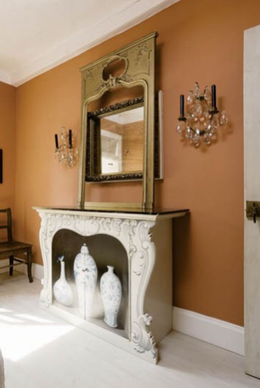 To nie kominek, lecz szafka tak sprytnie pomalowana, że wygląda jak marmurowy portal, w którym stoją chinskie wazy. Nad