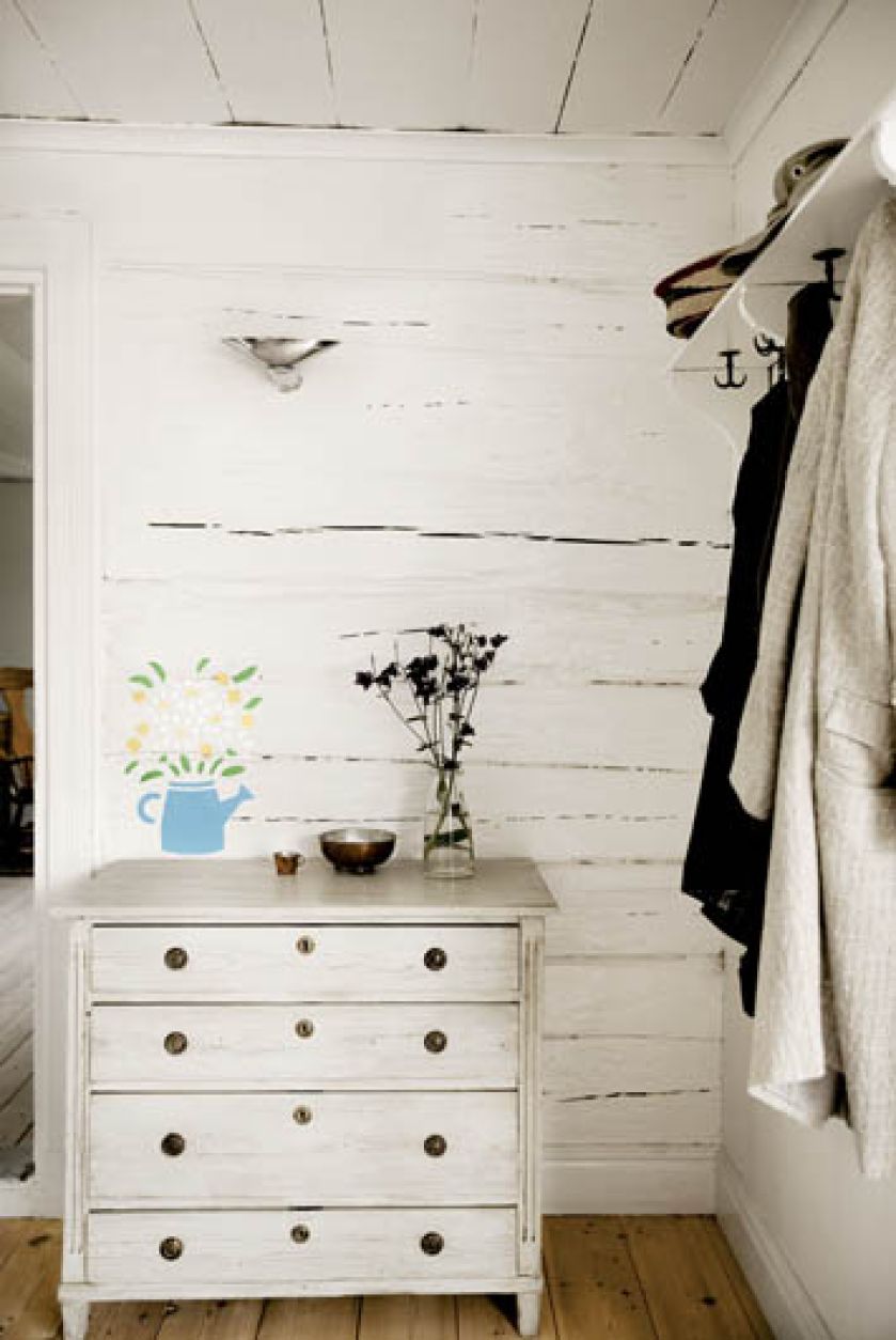 Wymalowany na ścianie dzbanek z kwiatami - jakby stał na komodzie.