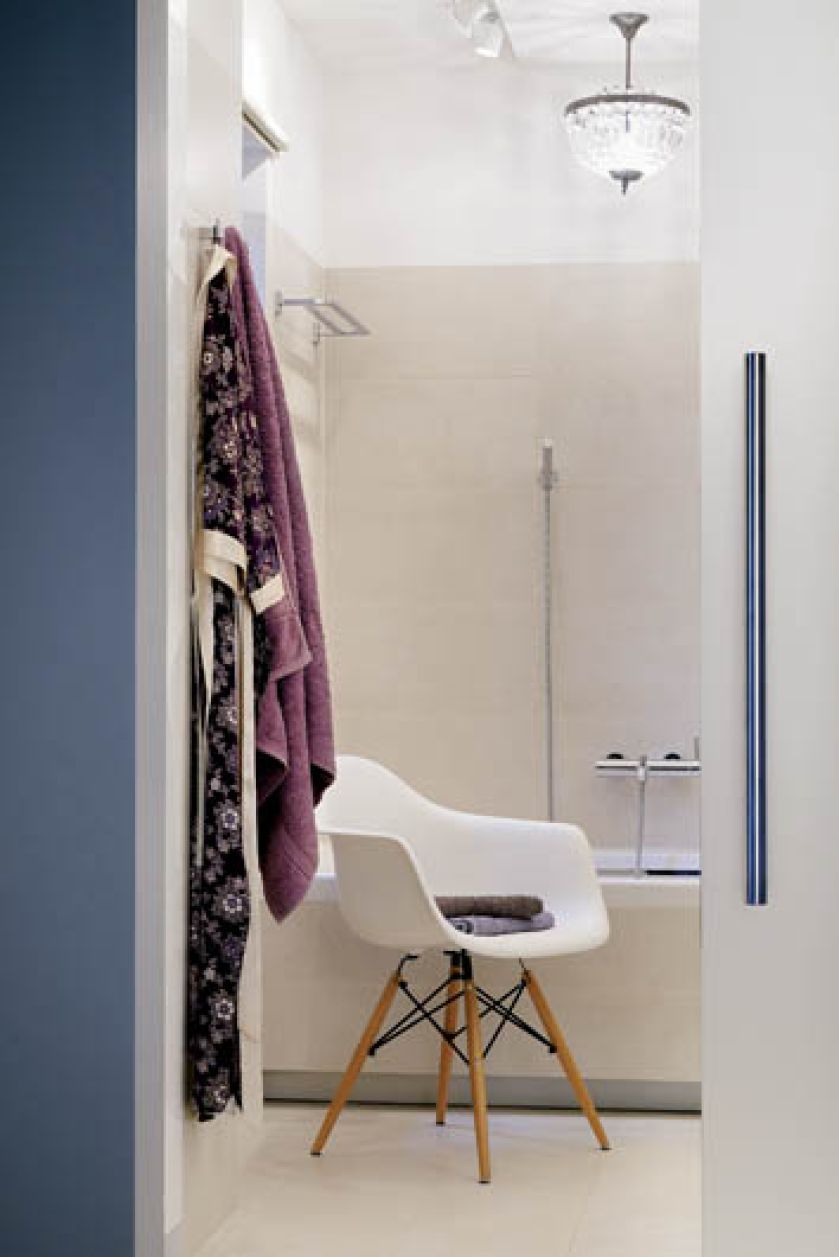 Ascetyczny salon kąpielowy połączony jest z sypialnią szklanymi drzwiami. Zdobi go głównie krysztalowy żyrandol, który