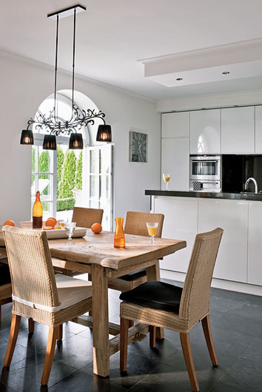 Biało-czarna nowoczesna kuchnia wycisza rozmach reszty domu. Nie brak w niej ciepłuch akcentów: pasiastej tapety