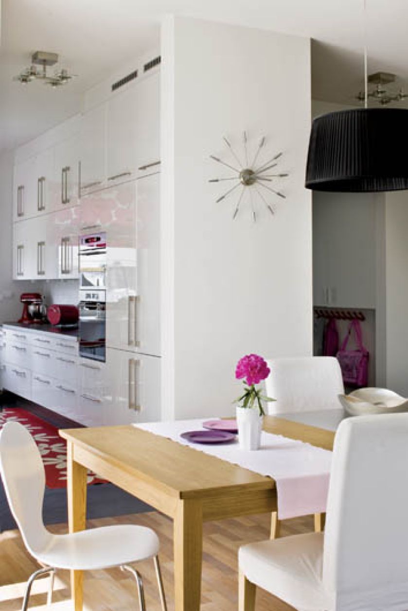 Biel na ścianach, drewniana podłoga i stół pozwalają oczom odpocząć.