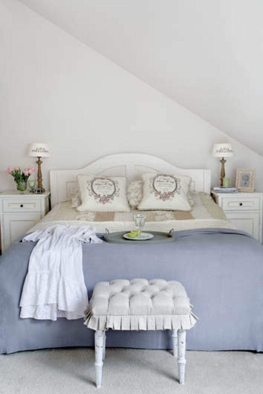 Kobiecy styl prowansalski króluje także w sypialni - biała rama łóżka, beżowe rustykalne poszewki na