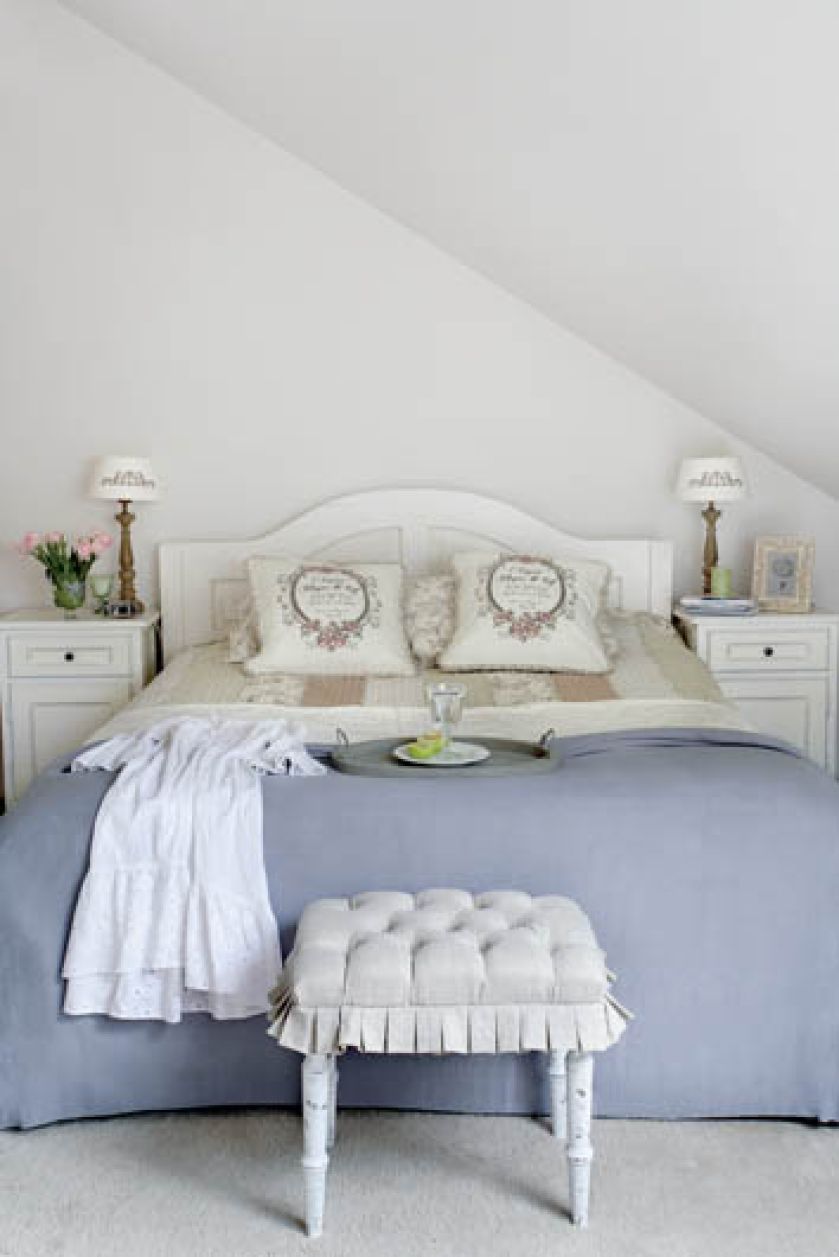 Kobiecy styl prowansalski króluje także w sypialni - biała rama łóżka, beżowe rustykalne poszewki na
