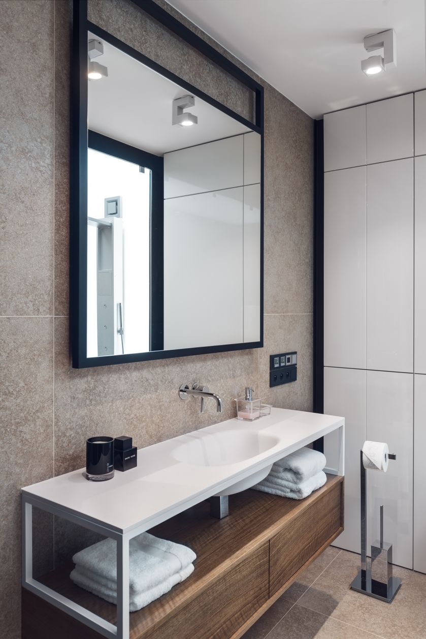 Luksusowa łazienka jest urządzona minimalistycznie. Proste kształty, jasne kolory, ciekawe połączenia faktur.