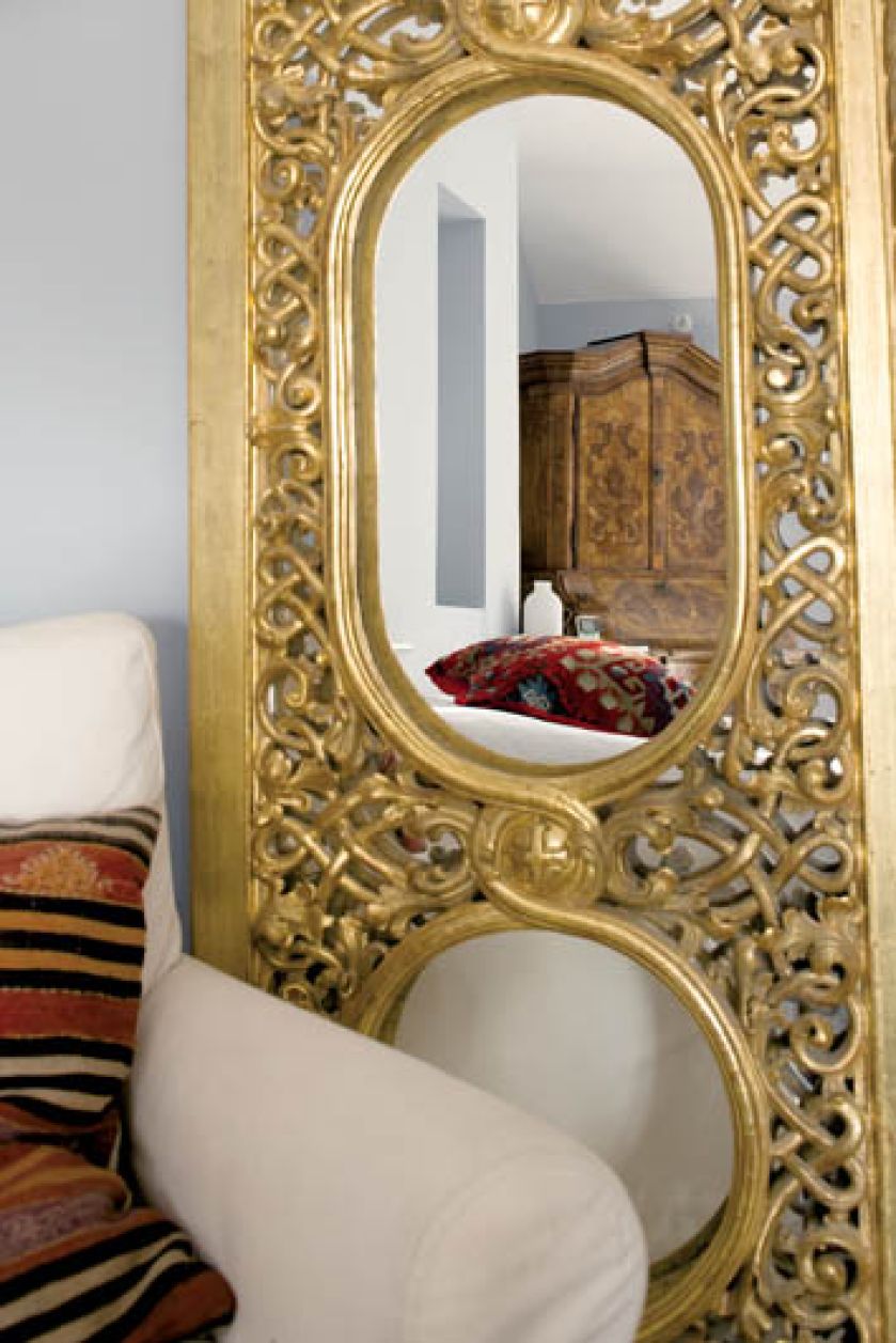 Lustro w złotej ramie dodaje sypialni blasku.