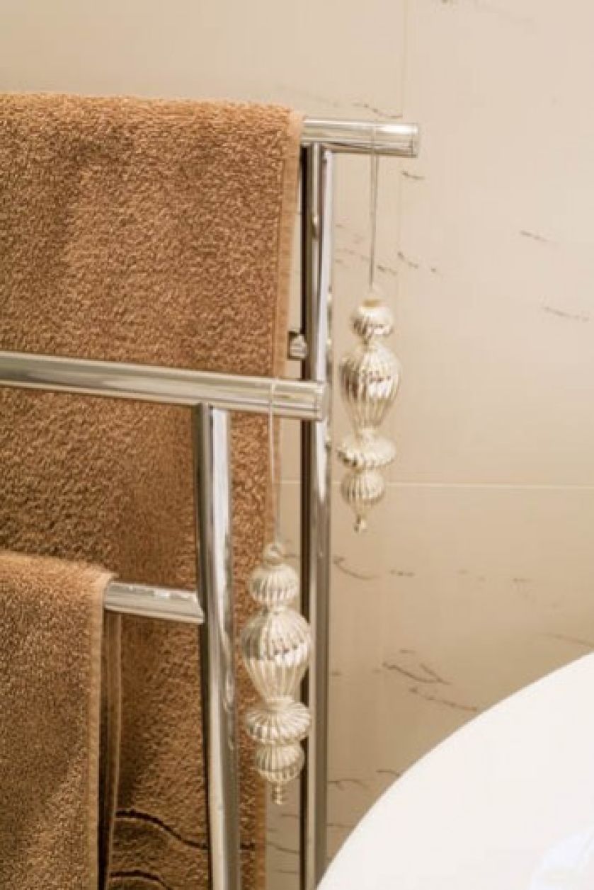 Na chromowanym wieszaku na ręczniki zawieszono... choinkowe bombki.