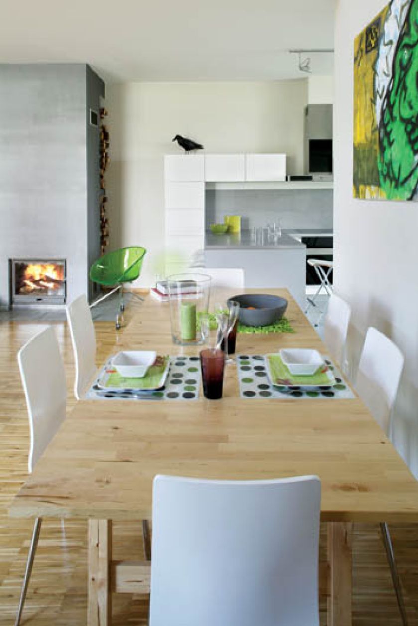 Skandynawskie biele, szarości oraz jasne drewno zostały ożywione zielenią. Proste krzesła kupili w Kare Design.