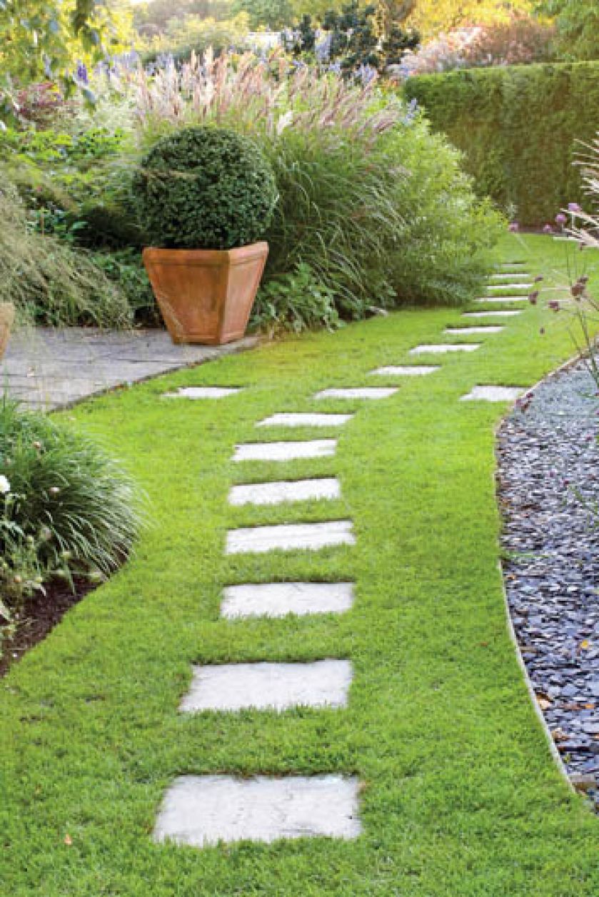 Szare betonowe płyty w trawniku dobrze grają z kora wysypana na rabatach. GAP PHOTOS/MEDIUM
