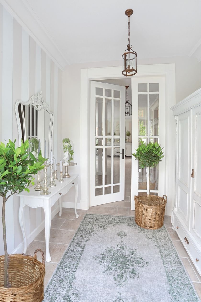 Świeczniki i popiersie pod kloszem z CHIC ANTIQUE obok zabytkowego, włoskiego lustra