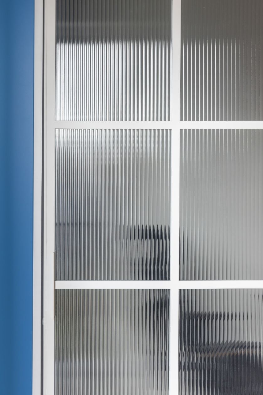 ryflowana szyba dzieląca domowe biuro i sypialnię