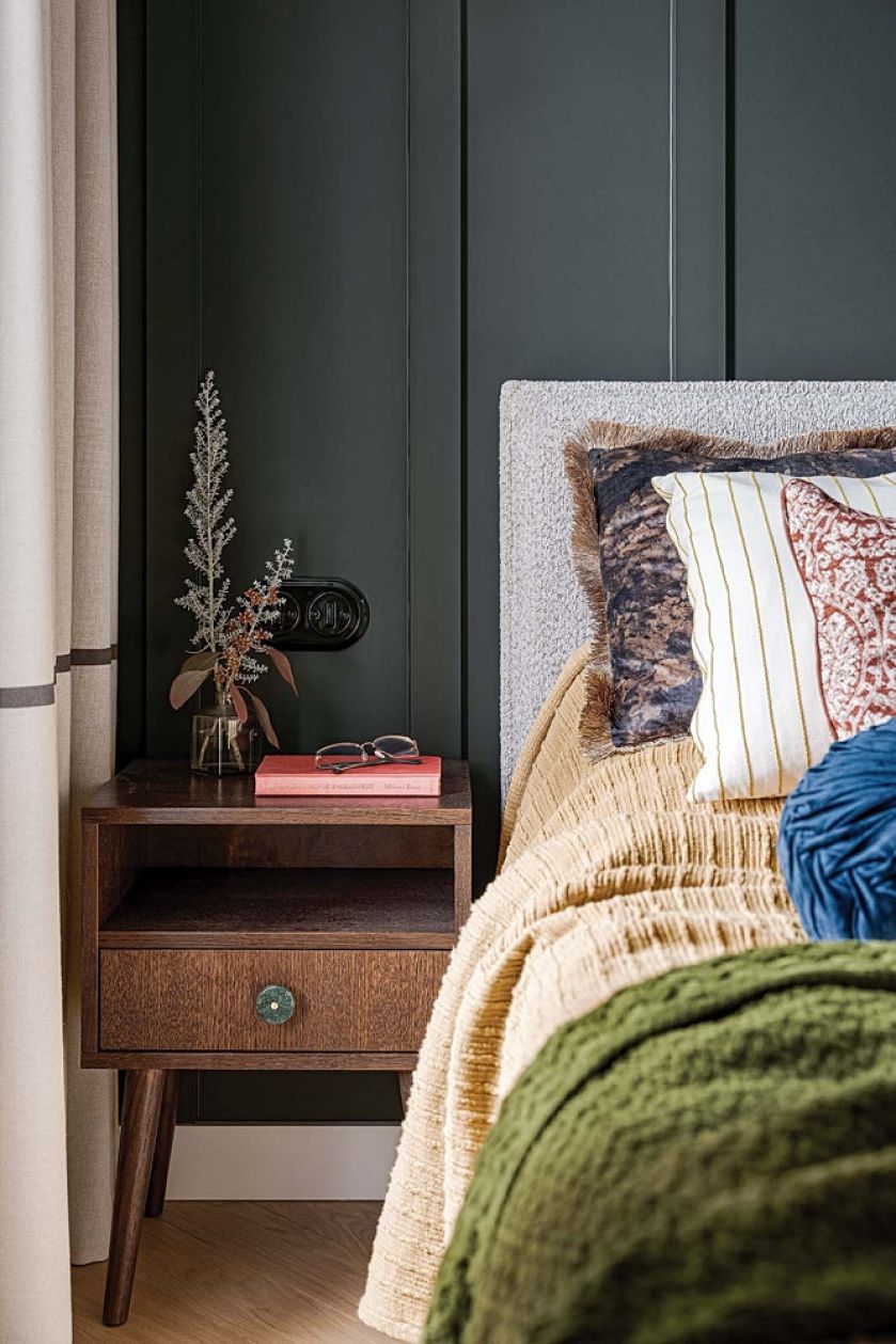 ciemny kolor ścian w sypialni i kontrastowe poduszki