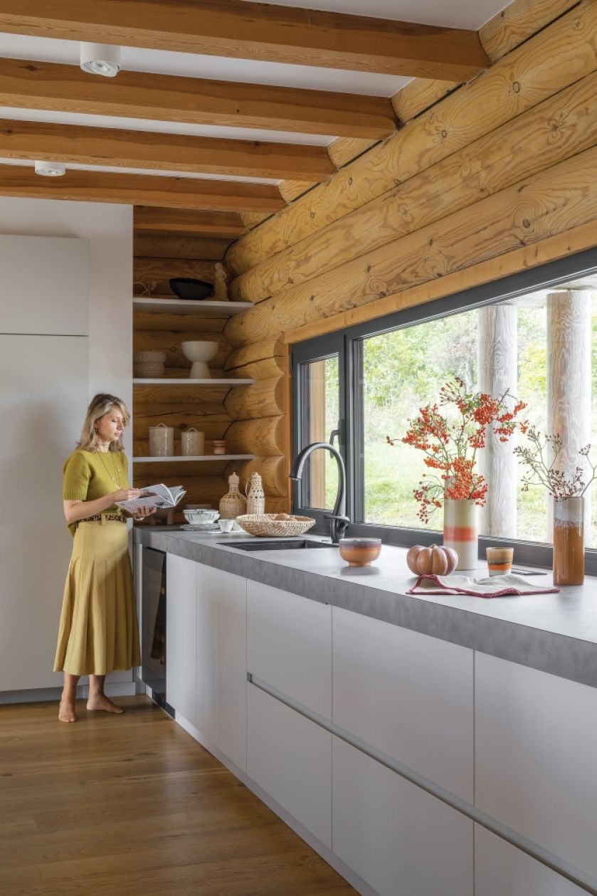 biała kuchnia z drewnem w domu z bali