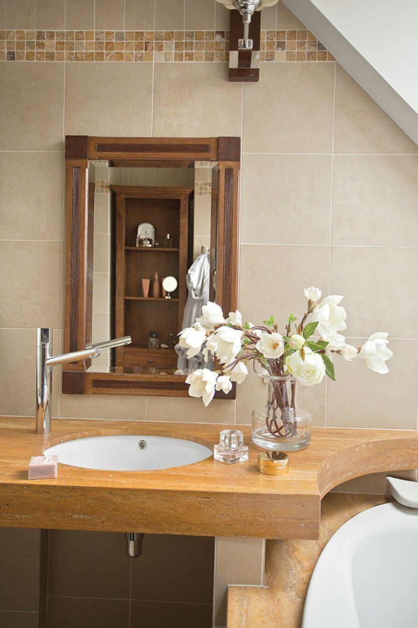 Beże i brązy, solidne dębowe meble i obraz z zabytkowym sportowym samochodem. Klasyka w najlepszym stylu.