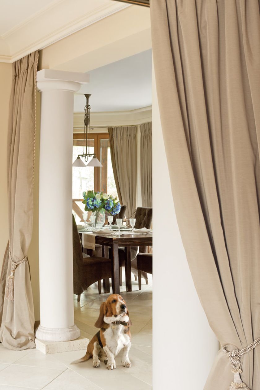 Beże i brązy, solidne dębowe meble i obraz z zabytkowym sportowym samochodem. Klasyka w najlepszym stylu.