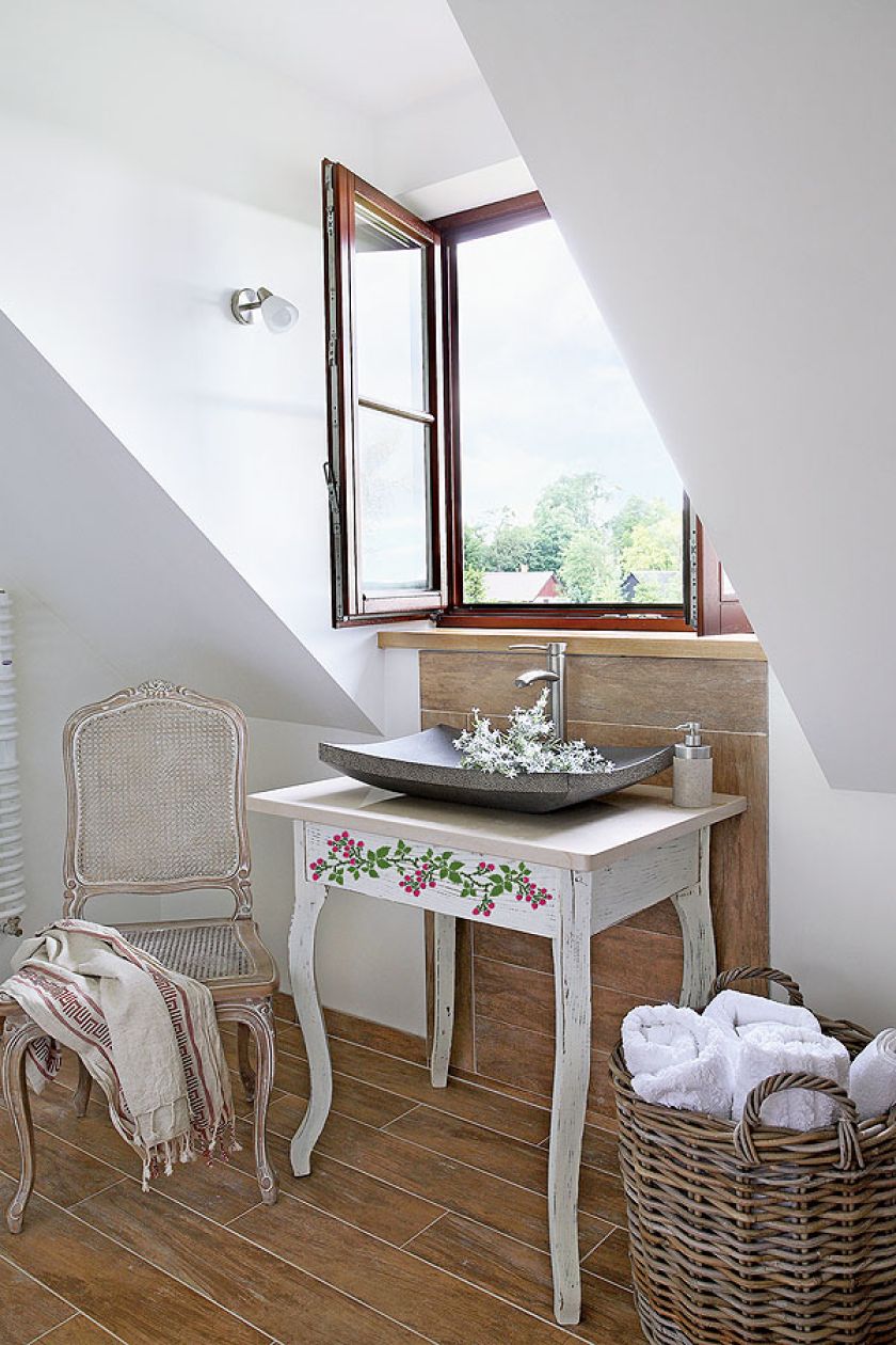 Biały stolik i krótki rzucik filoletowych jeżyn - idealny mebel-dekoracja do łazienki w stylu prowansalskim.