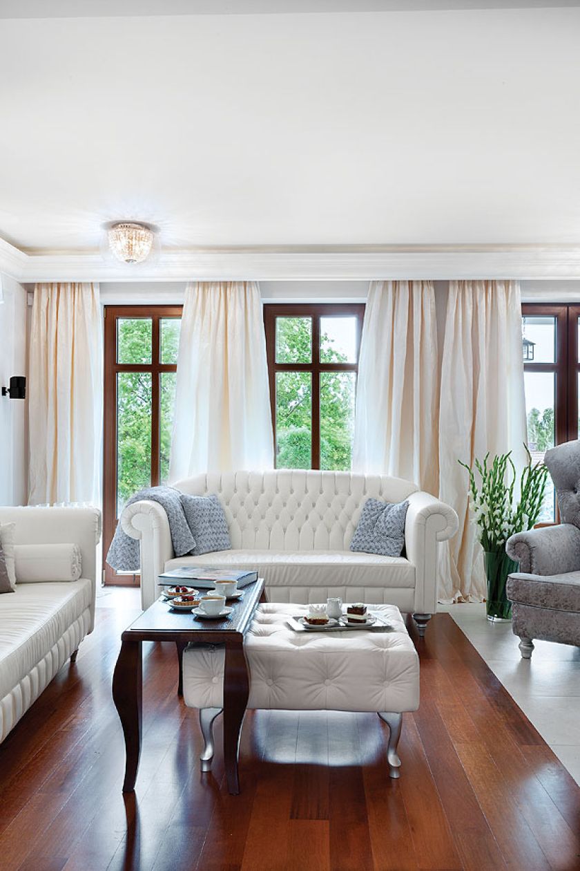 Dominują tu biel i delikatne szarości oraz błękity. W oknach długie zasłony.