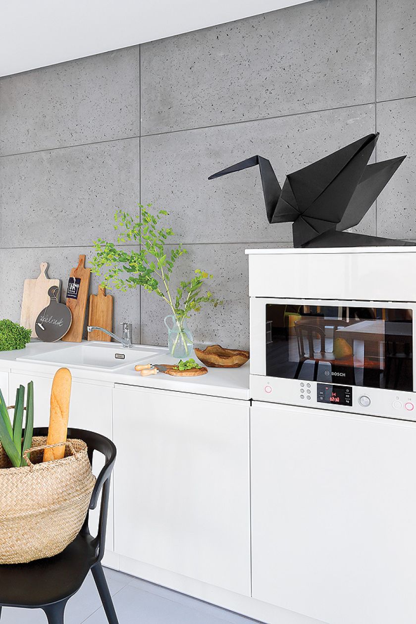 Jak ocieplić betonową ścianę? Dodać kilka drewnianych desek, mis i origami - papierowego żurawia (sklep Moher).