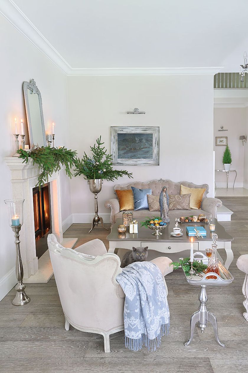 Na kominku prosty, ale efektownie wyglądający stroik z gałązek świerkowych.