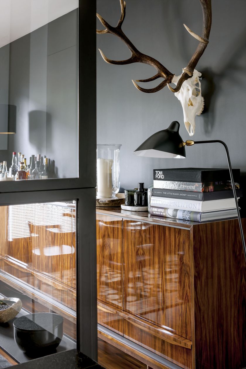 Na pierwszym planie stojąca lampa projektu Serge’a Mouille’a.