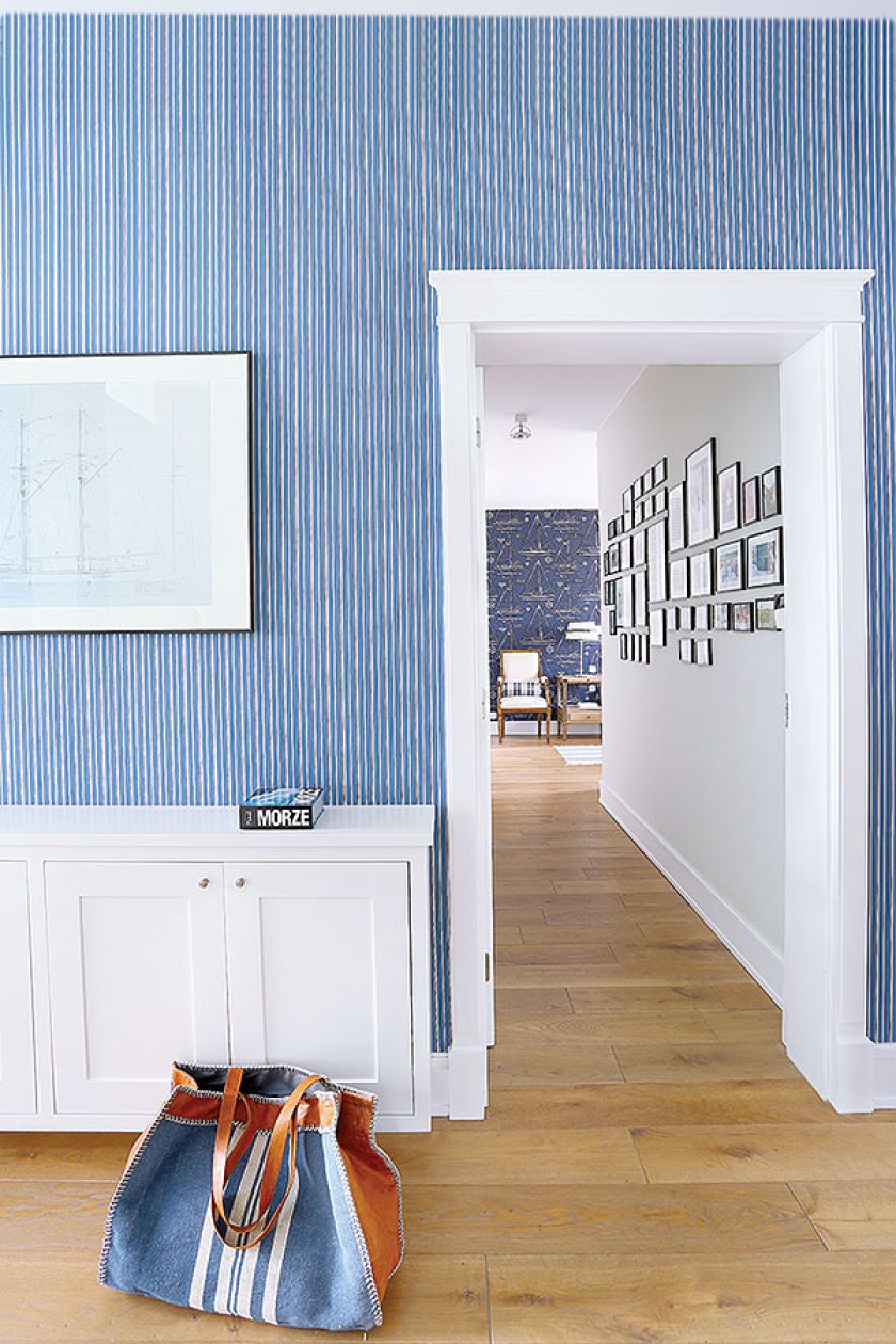 Niebieska tapeta w delikatne biało-granatowe paseczki nadaje wnętrzom morskiego klimatu.