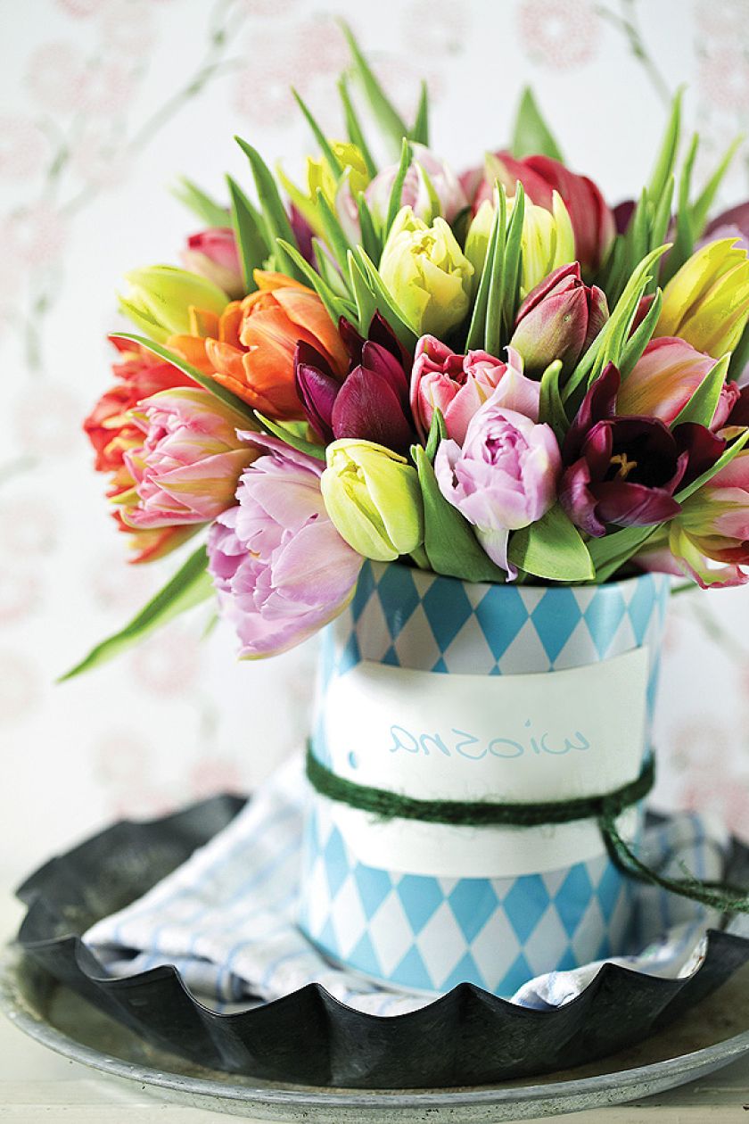 Pomysł na dekorację z tulipanów. Bukiet stoi w wazonie, który jest zrobiony ze sterej puszki.
