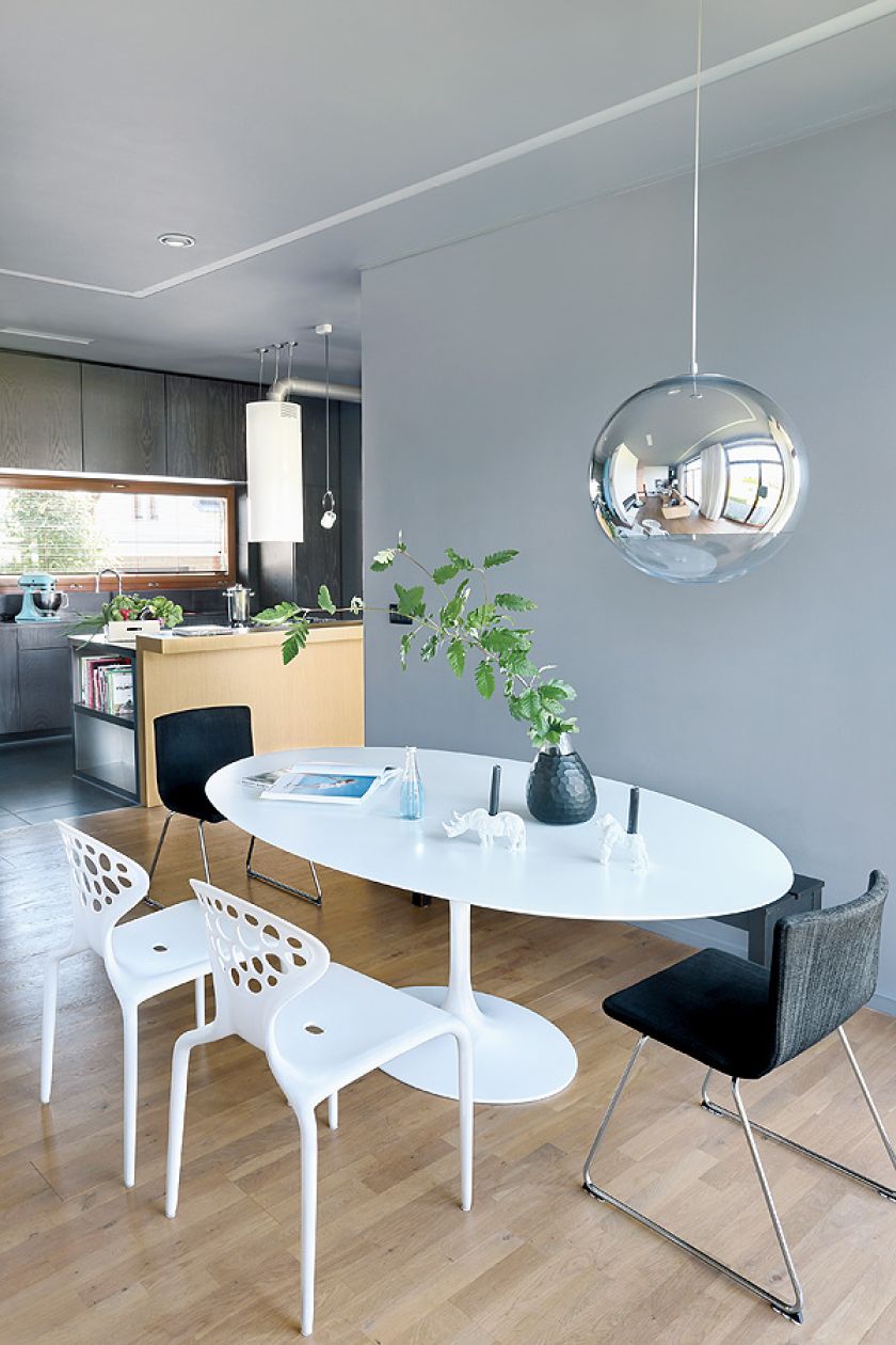 Stół Tulip i krzesła Supernatural. Czarny wazon i świeczniki z Bo Concept.