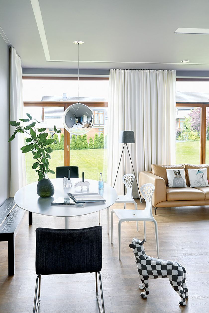 Stół Tulip i krzesła Supernatural. Czarny wazon i świeczniki z Bo Concept.