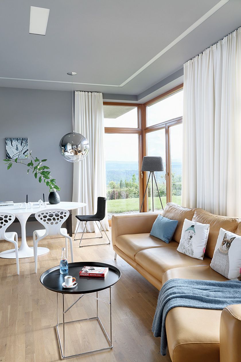 Stół Tulip i krzesła Supernatural. Czarny wazon i świeczniki z Bo Concept.