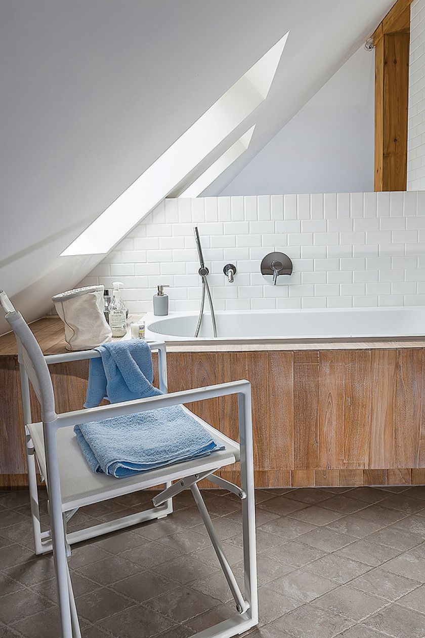 Styl skandynawski: biele błękity i szarości na tle drewnianej ściany. W domu pomieszano wiele stylów