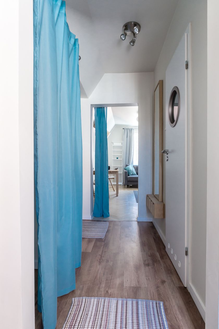 Zamiast drzwi do poszczególnych pomieszczeń, zawieszono turkusowe kotary, które nadają wnętrzu marynistyczny charakter.