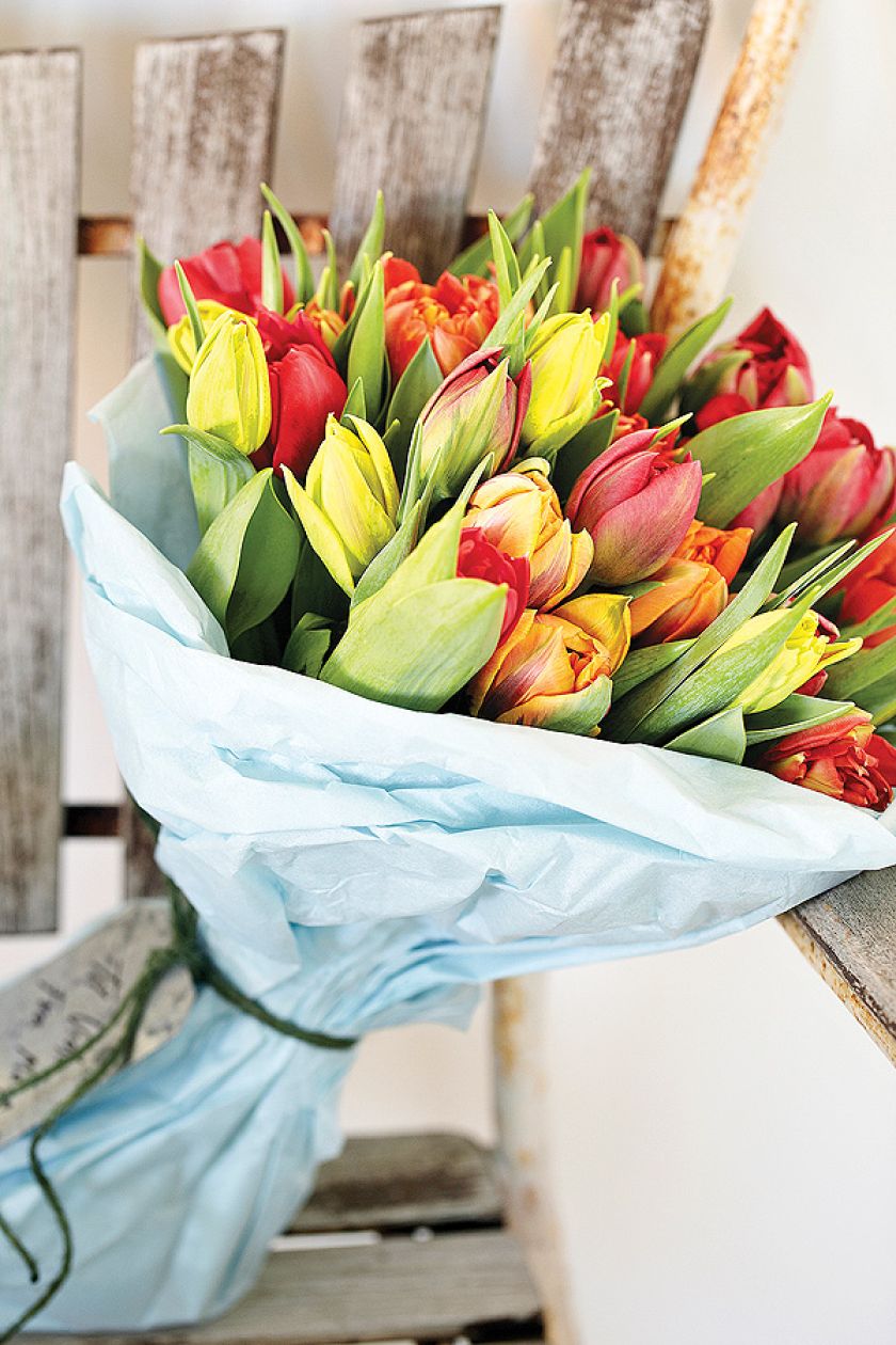 Zółto-czerwony bukiet tulipanów w dekoracyjnym opakowaniu.