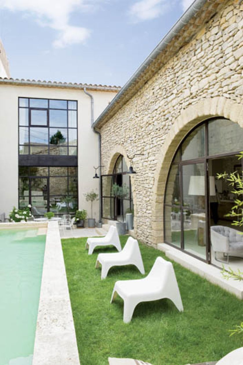 Basen ma 9 metrów, pas trawy, dookoła stoją terakotowe donice z hortensjami i bukszpanem.