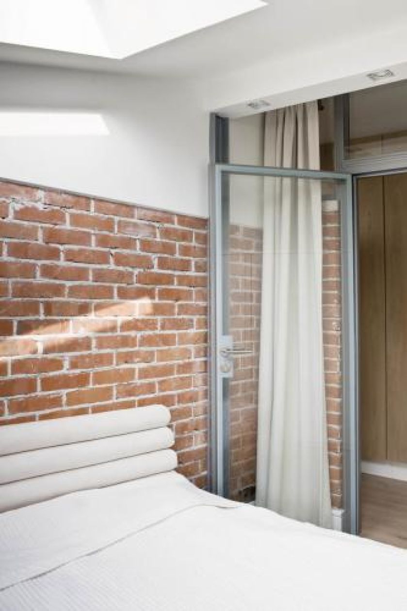 Ceglana ściana kontrastuje z jasnym wnętrzem.