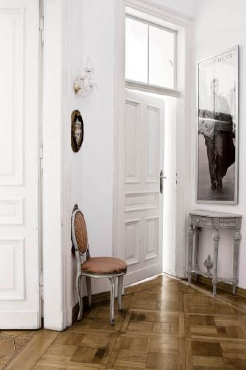 Czarno- białe portrety filmowych gwiazd zestawione z francuskimi, bogatymi meblami nadają wnętrzon lekkości.