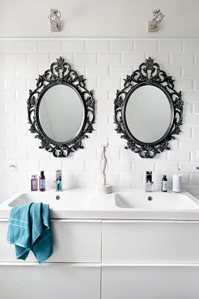 Dekoracyjne ramy luster na białych kaflach.