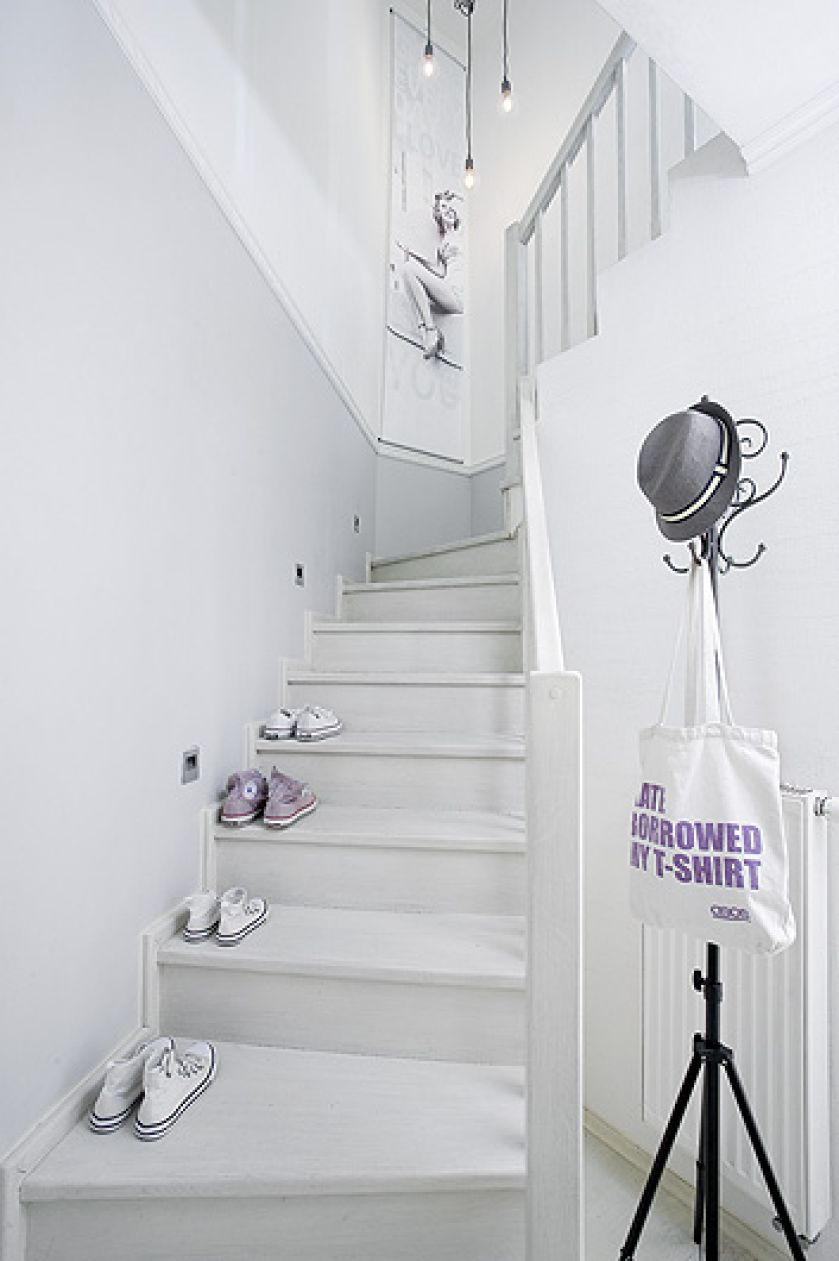 Jasno urządzone wnętrze, z kominkiem, ogromnymi oknami i drewnianym tarasem.