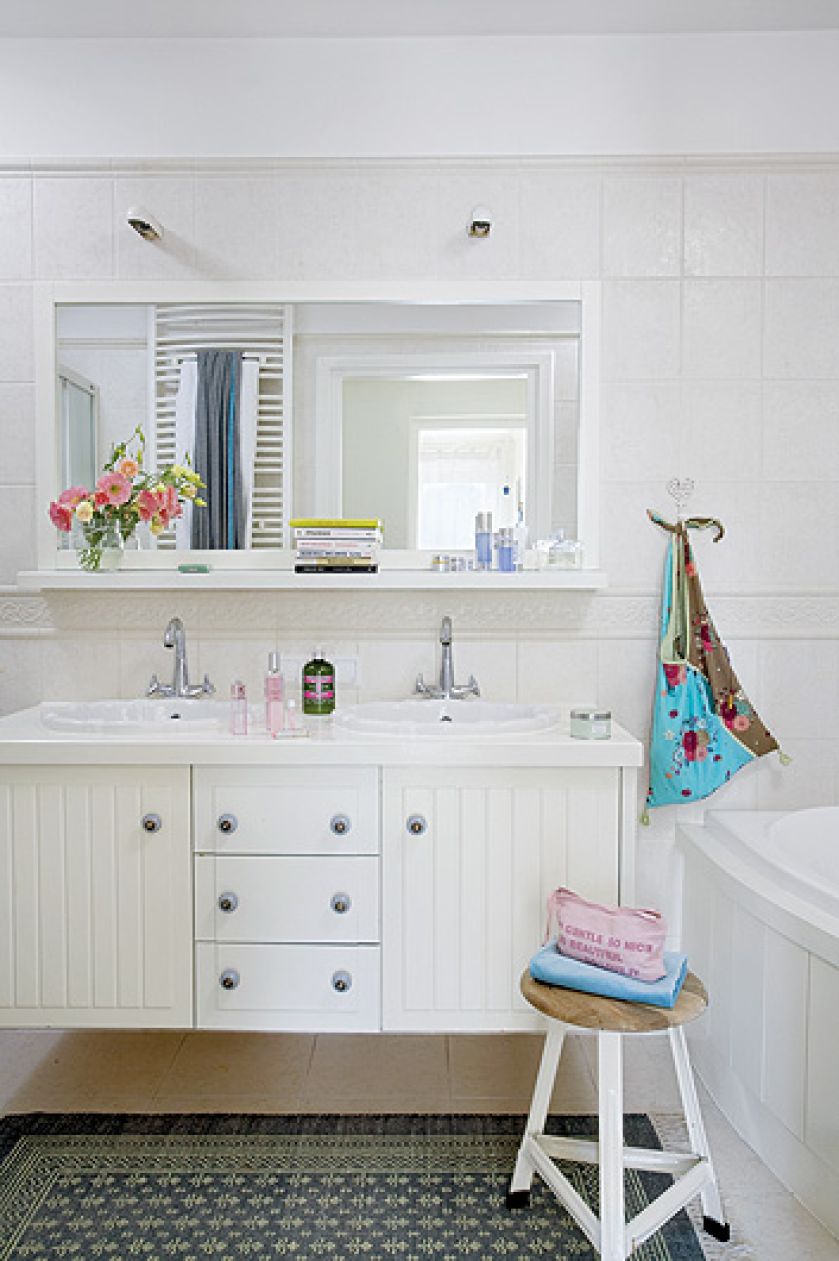 Jasno urządzone wnętrze, z kominkiem, ogromnymi oknami i drewnianym tarasem.