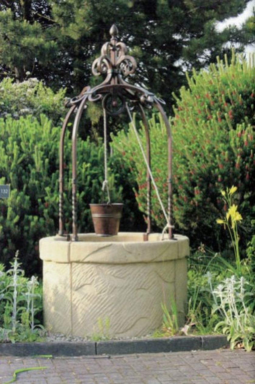 Kamienna studnia z ręcznie kutym stalowym zwieńczeniem. KRYSZTAŁ/ROBERS