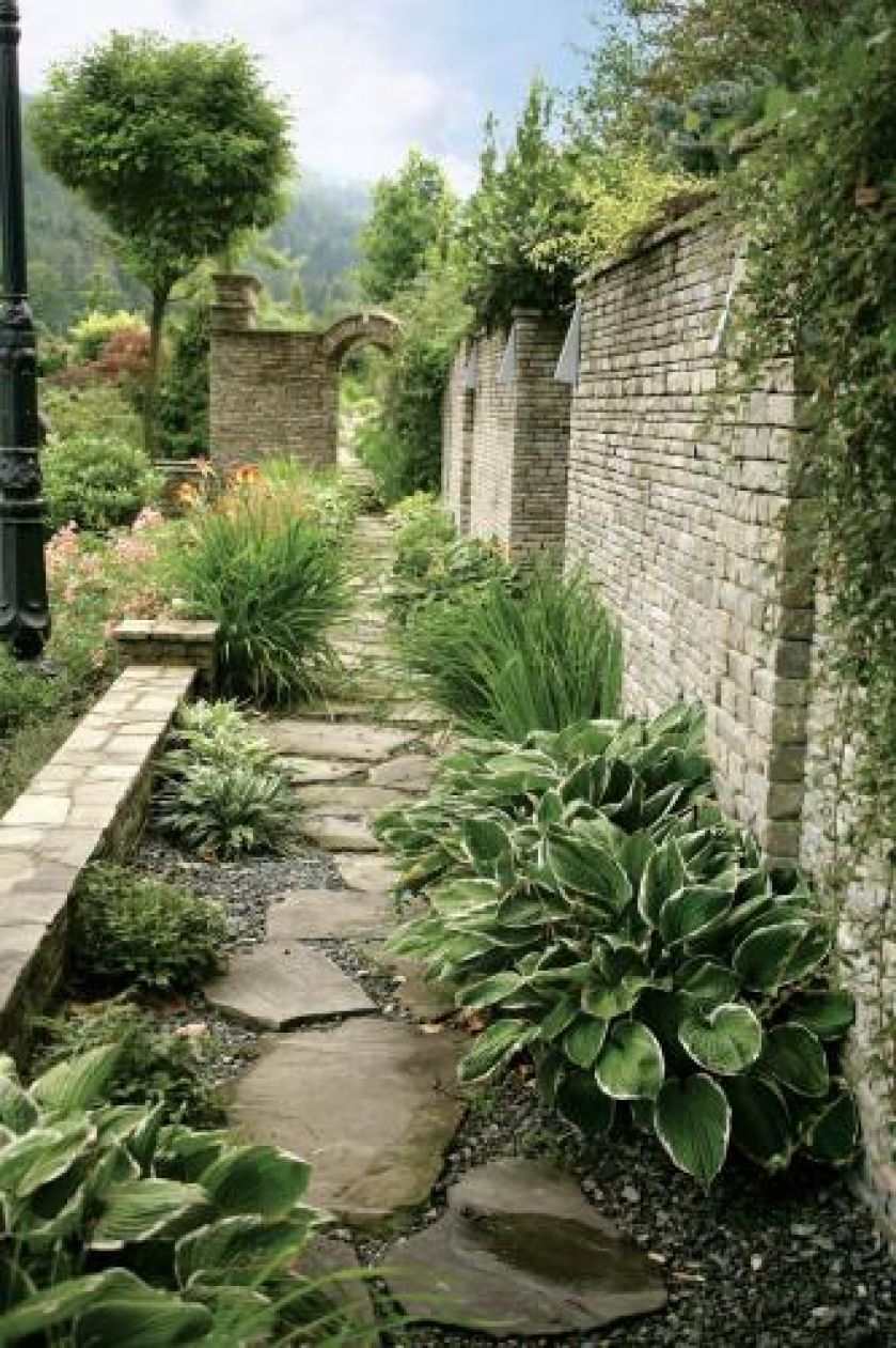 Kamienny mur zdobi i urozmaica ogród.