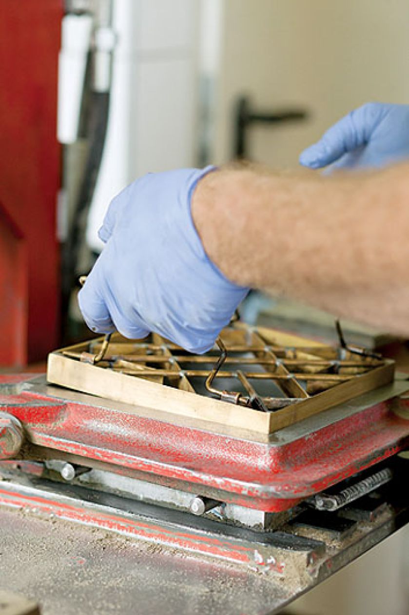 Metalowy wzornik wkładamy do stalowej formy. Potem wlewamy do niego masę cementowo-marmurową i pod prasę. Ale diabeł tkwi w