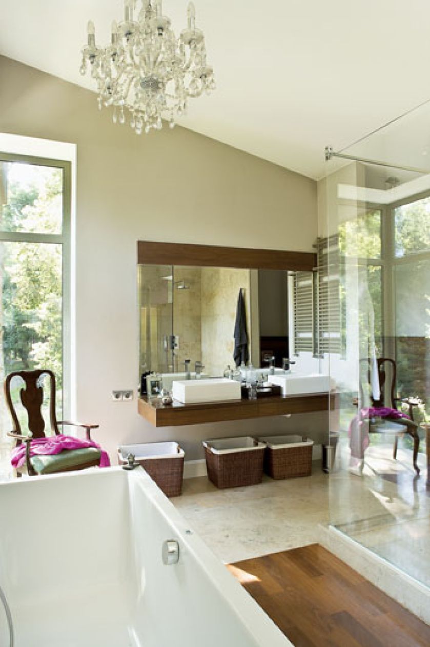 Na podłodze wapień, fornirowany blat pod umywalkami, drewniana podłoga i kosze nawiązują do stylu kolonialnego.