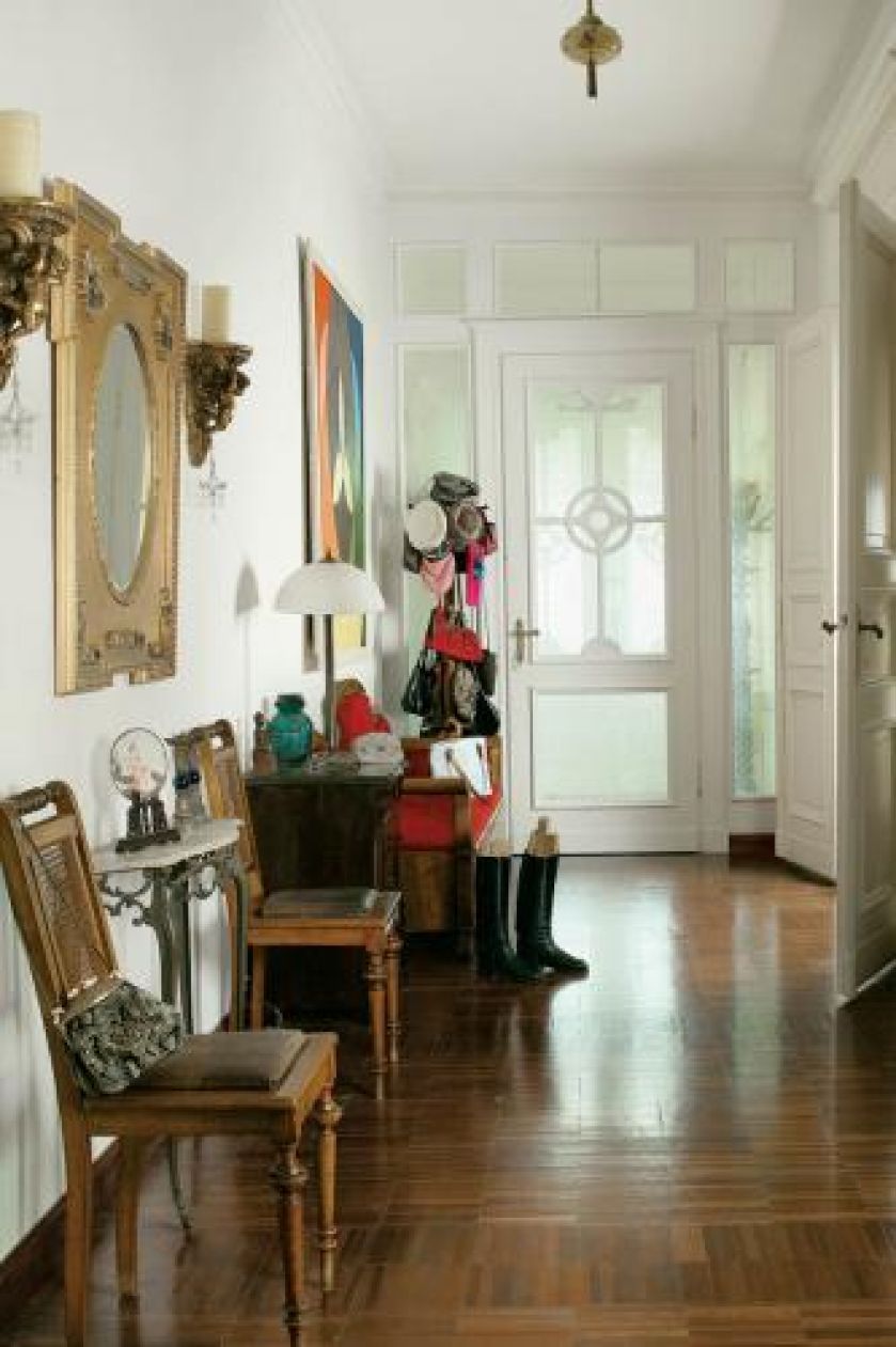 Nad konsolą wisi lustro w zdobionej ramie.