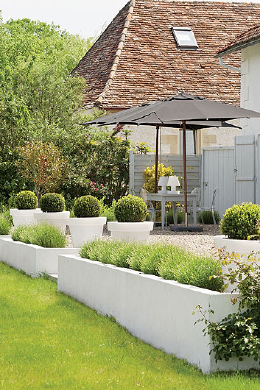 Nowoczesne, świecące donice na tarasie.