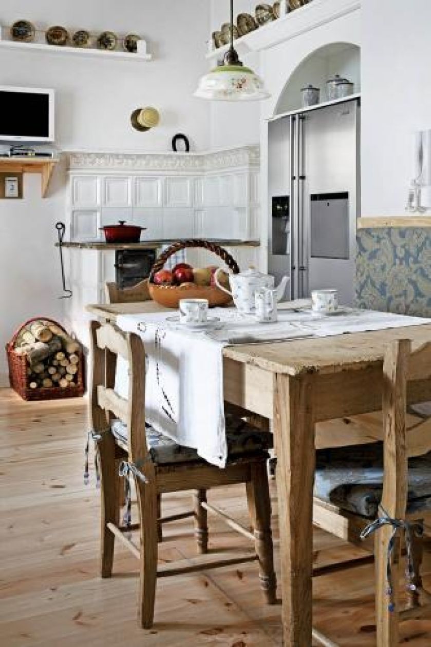 Obok nowoczesnej lodówki stary piec. W ogrodzie sztuki