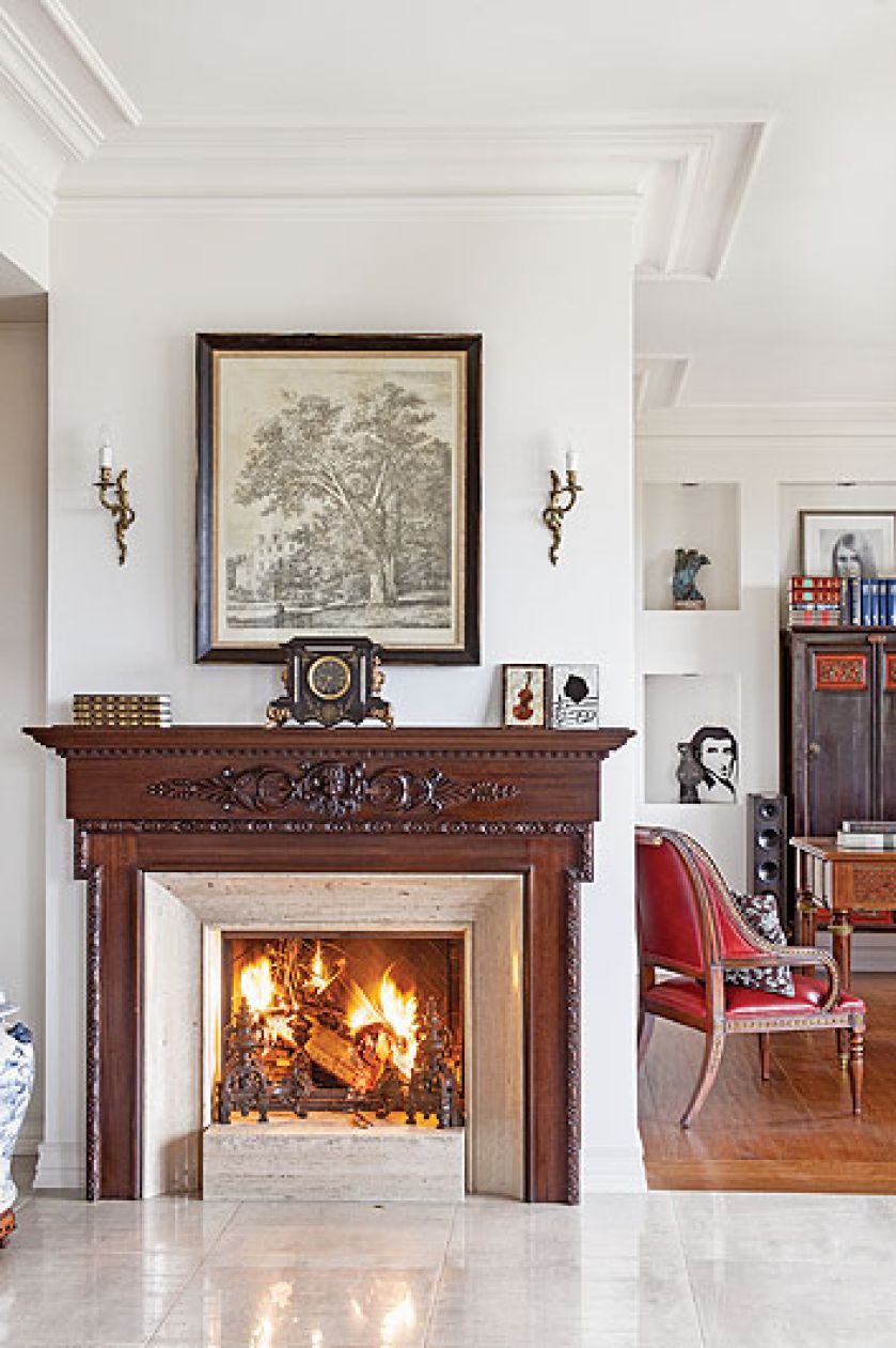 Przy kominku stoi wiktoriański fotel wyaptrzony na targu.