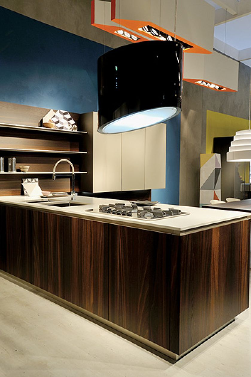 Kuchnia urządzona nowocześnie z okapem kuchennym nad wyspą.