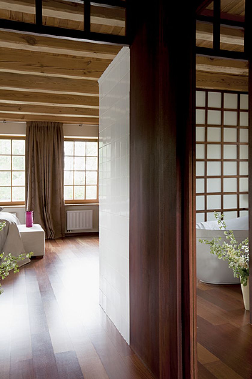 Sypialnia jest oddzielona od łazienki delikatnym przepierzeniem zrobionym z drewna i matowego szkła.