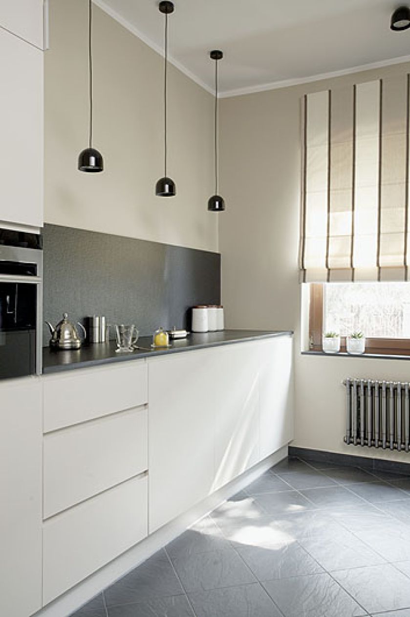 Szafki zaprojektowane przez Agnieszkę Pudlik. Granitowy blat do prostych mebli. Ten sam kamieć jest położony na ścianie.