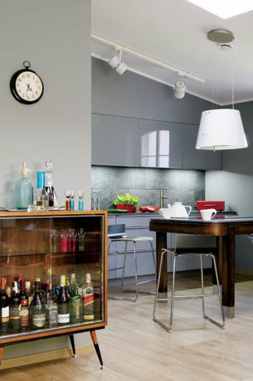 Ton kuchni nadają szarości błyszczace i matowe. Prostemu drewnianemu stołowi szlachetności i urody dodały stalowe