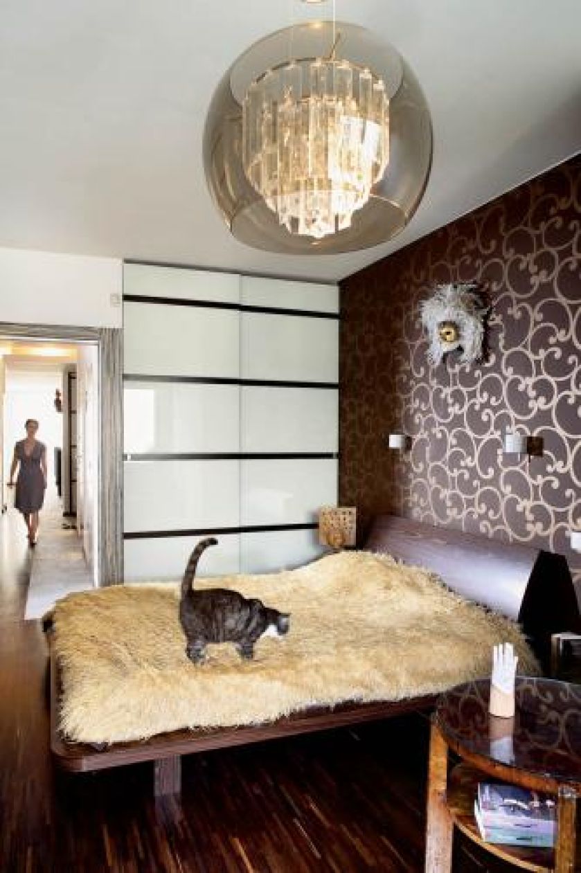 W sypialni drewniane łóżko i stolik.